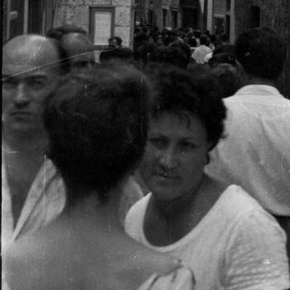 Black and white image of people in a narrow, old street.