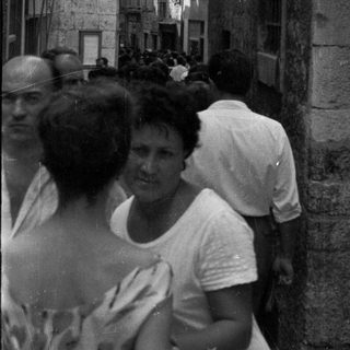 Black and white image of people in a narrow, old street.