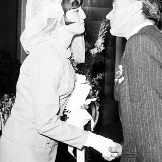 Black and white photo shows a wedding couple and guests.