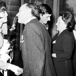 Black and white photo shows a wedding couple and guests.