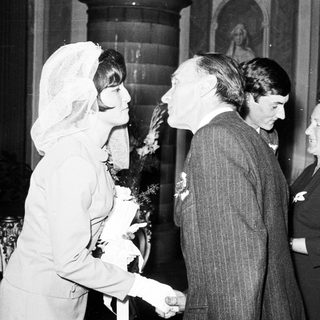 Black and white photo shows a wedding couple and guests.