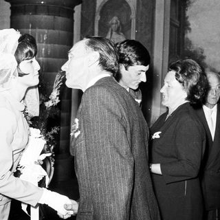 Black and white photo shows a wedding couple and guests.