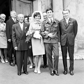 Black and white photo of a wedding party outside.