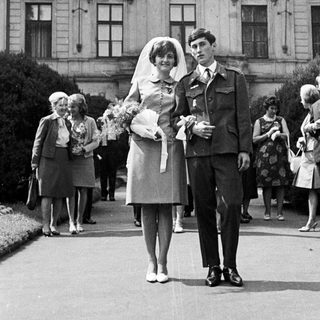 Couple exits building, likely a wedding ceremony.