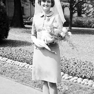 Black and white photo of a bride standing outdoors.