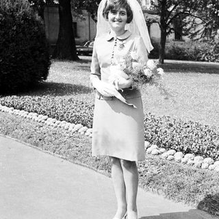 Black and white photo of a bride standing outdoors.
