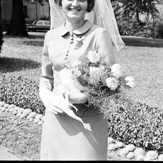 Black and white photo of a bride holding flowers.