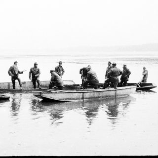 Group of men in boats on a body of water.