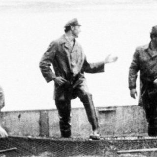 Group of men in boats on a body of water.