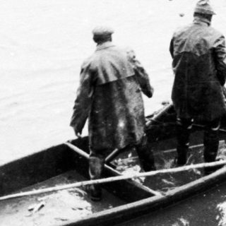 Men near boats, possibly involved in rescue or transport.