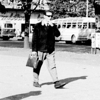 Woman and child walking down a street in a city.