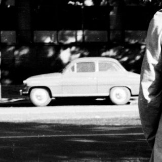 Man and child walk away, pulling a cart.