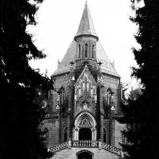 Black and white photo of a stone building with a spire.