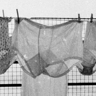 Laundry hangs on a line covered in snow.