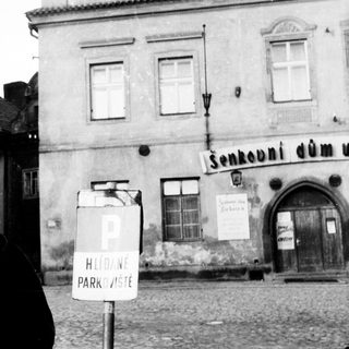 Black and white photo of a woman near a building.