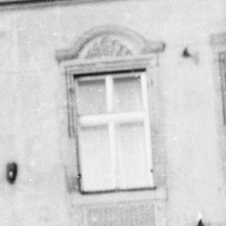 Black and white photo of a woman near a building.