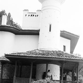 Black and white image of a mosque with a minaret.