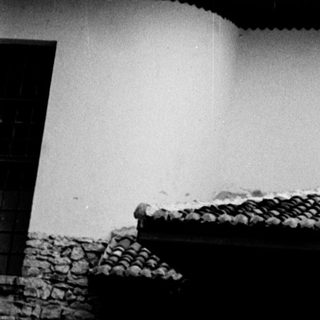 Black and white image of a white minaret and building.