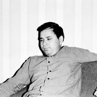 Black and white photo of a man seated in a chair.