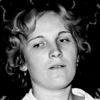 Woman holding an acoustic guitar, black and white portrait.