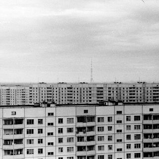 A large, repetitive apartment building with numerous balconies.