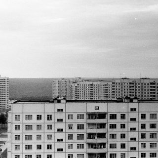 Black and white view of apartment buildings and a park.