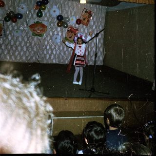A performer juggling fruits on stage.