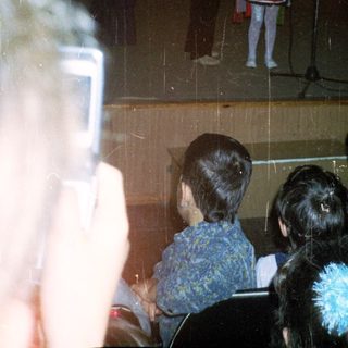 Children's stage performance with puppeteers and a young performer.