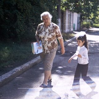 Two women walking together on a quiet road.