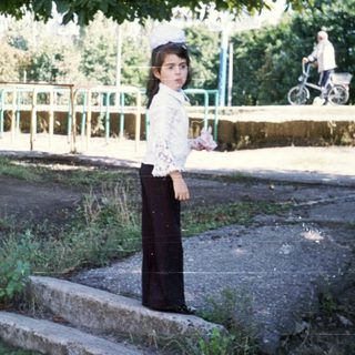 Young woman standing outdoors near stairs.