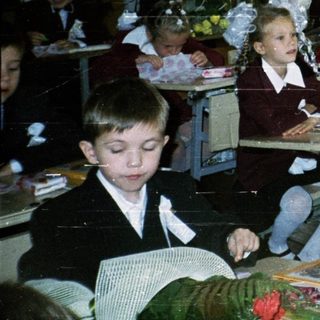 Classroom with young students dressed in formal school attire.