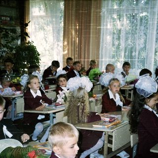 Classroom with young students dressed in formal school attire.