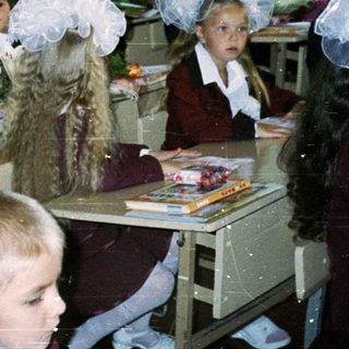 Classroom with young students dressed in formal school attire.