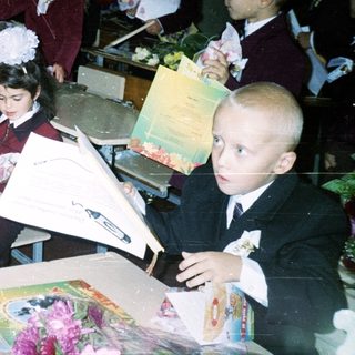 Schoolchildren in formal attire crafting graduation bouquets.