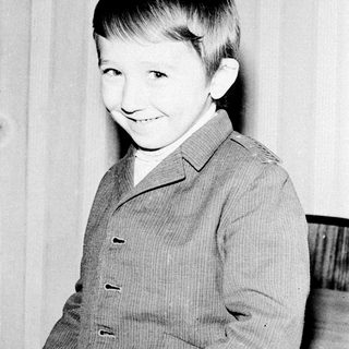 Young boy smiling in vintage suit.