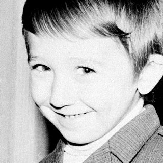 Young boy smiling in vintage suit.