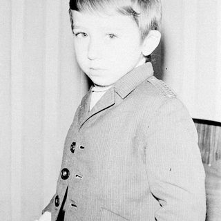 Young boy in vintage suit, early 1900s-style portrait.