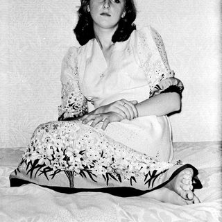 Young woman in vintage dress sitting with cat.
