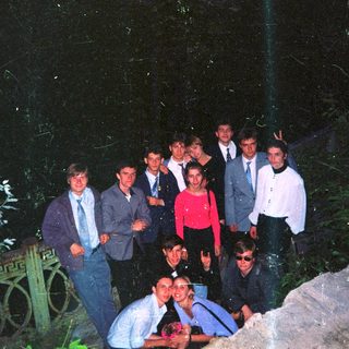 Group of people posing outdoors at night.
