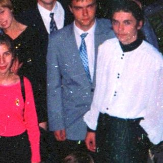 Group of people posing outdoors at night.