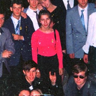 Group of people posing outdoors at night.