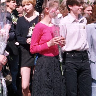 Graduating students presenting flowers to a woman.