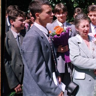 Graduating students presenting flowers to a woman.