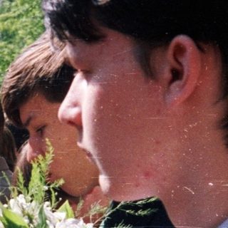 Group of students holding flowers outdoors.