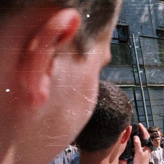 People gathered outside a building, likely for a public event or demonstration.