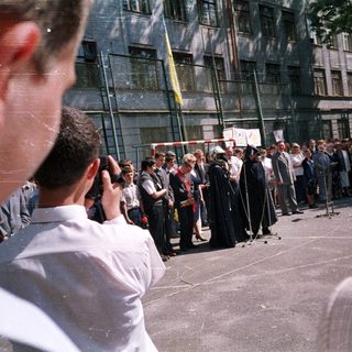 People gathered outside a building, likely for a public event or demonstration.