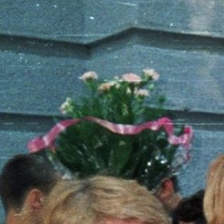 Graduation ceremony with students holding flower bouquets.