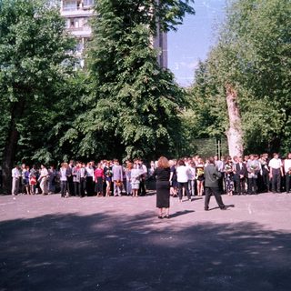 Group of people gathered outdoors in formal attire.
