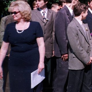 Group of students placing flowers at a monument.