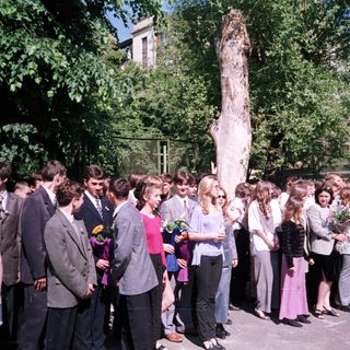 Group of students placing flowers at a monument.